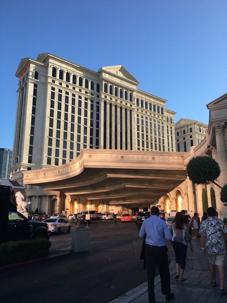 Caesars Palace entrance at golden hour with crowds on the Las Vegas Strip